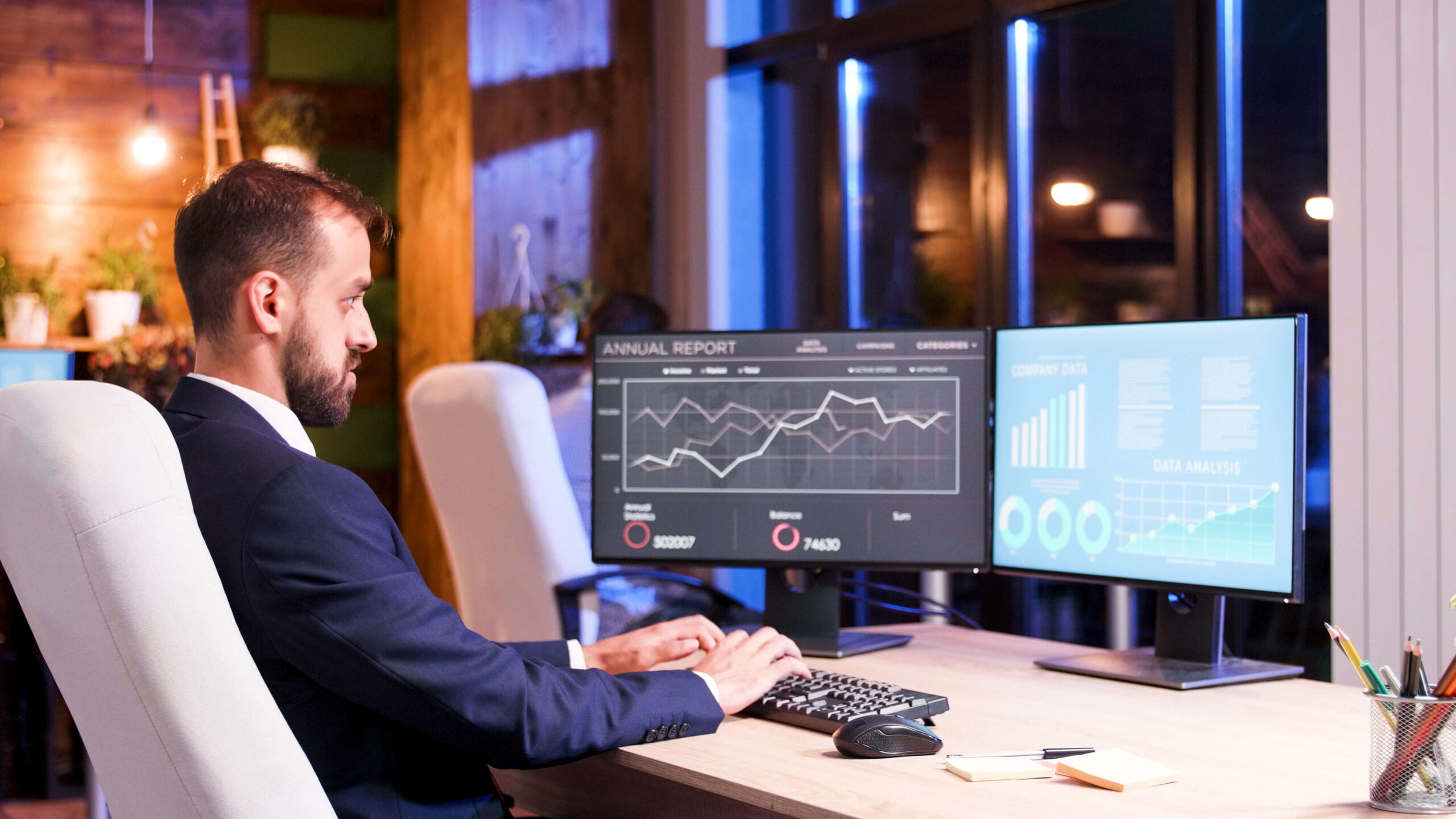 Empresário analisando gráficos financeiros no computador representando a diferença entre faturamento alto e lucro real na empresa.